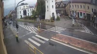 Une place avec une fontaine, des rues